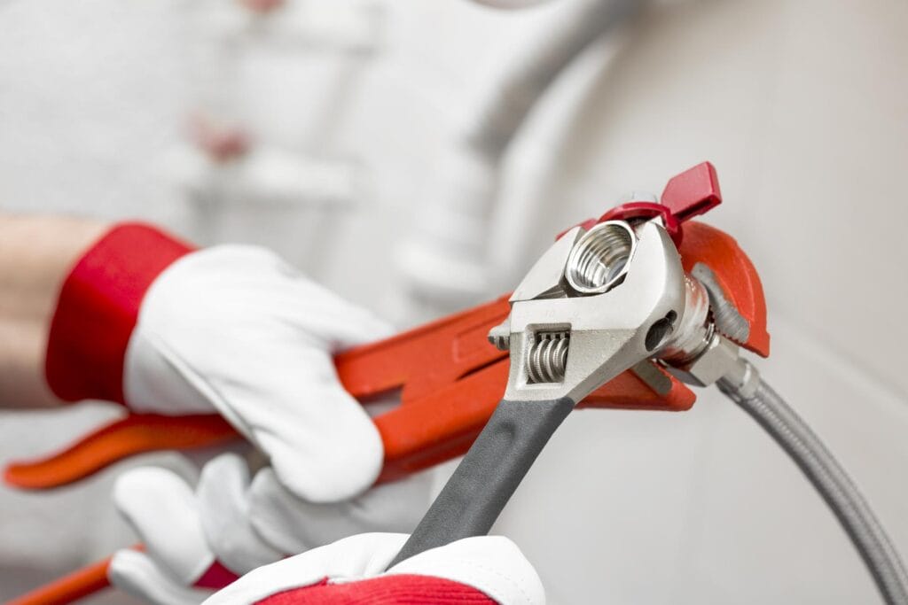 Plumber holding pipe wrenches for an emergency repair in Hialeah