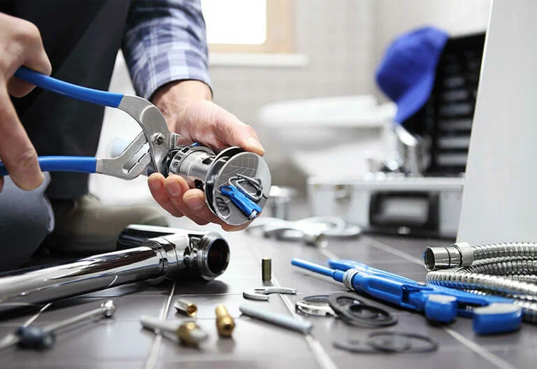 Technician repairing a plumbing fixture with professional tools in Hialeah