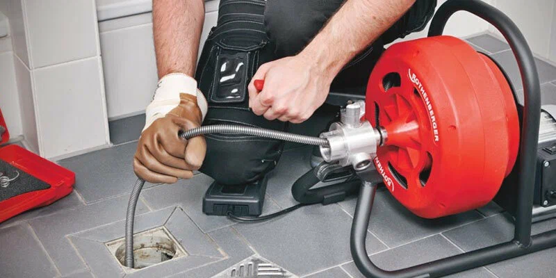 Plumber using a drain-cleaning machine in Hialeah