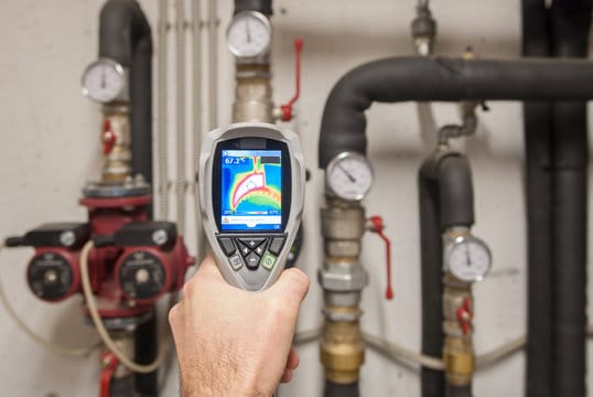 Plumber using a thermal imaging camera to inspect pipes in Hialeah