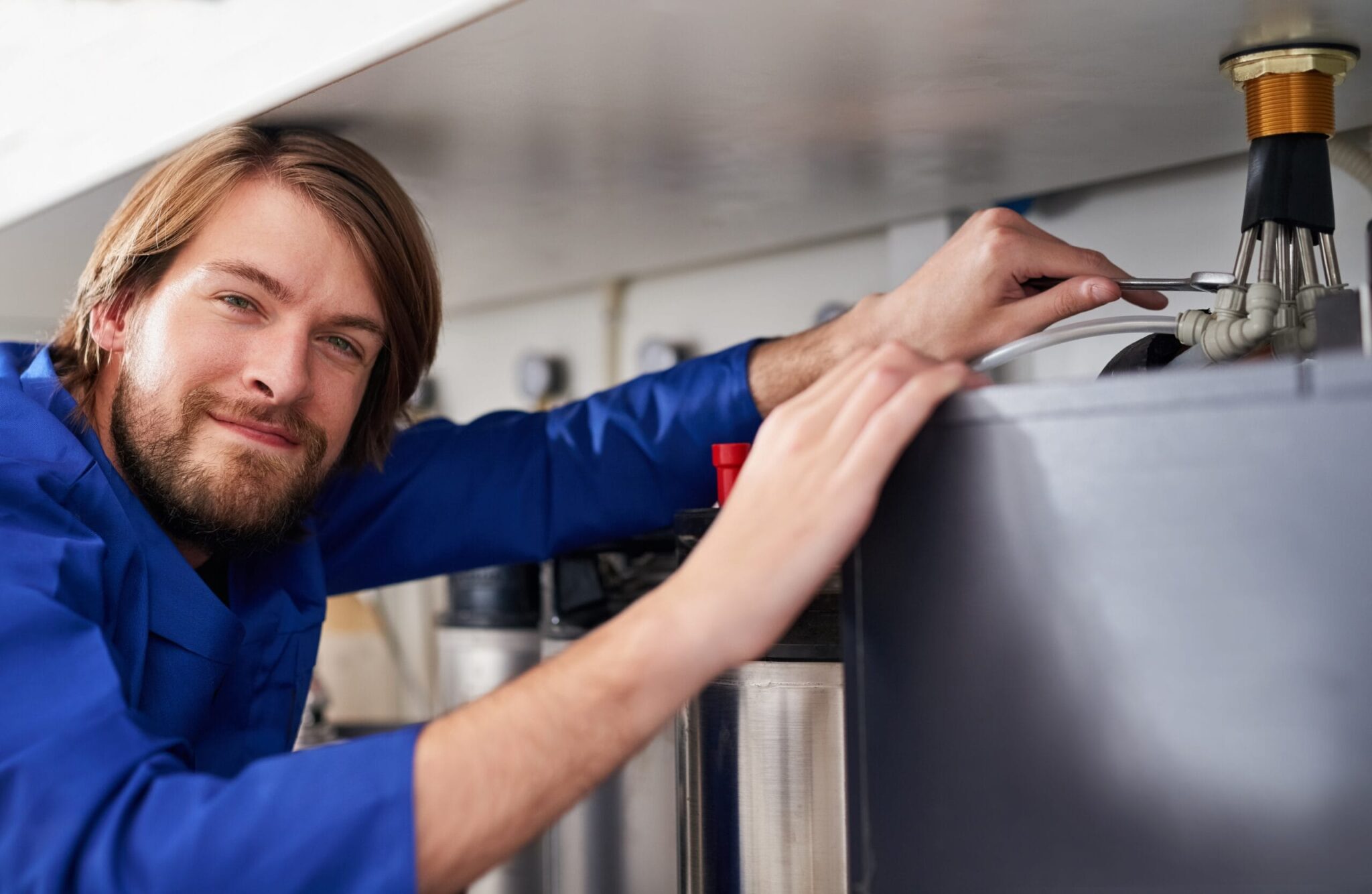 Technician servicing a residential water heater tank in Hialeah